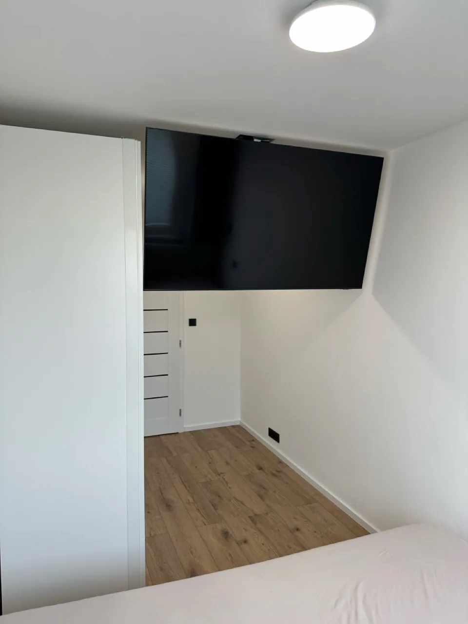 Obývací pokoj s televizní stěnou, sedačkou a kuchyní