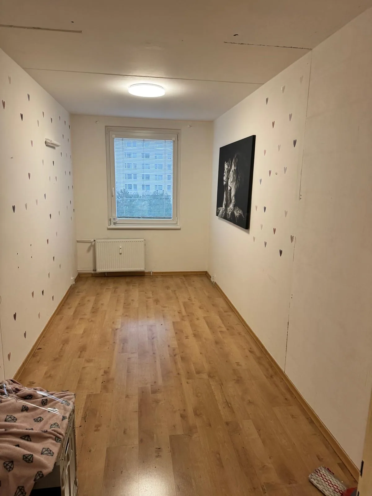 Původní pokoj s dekorací na stěnách a dřevěnou podlahou