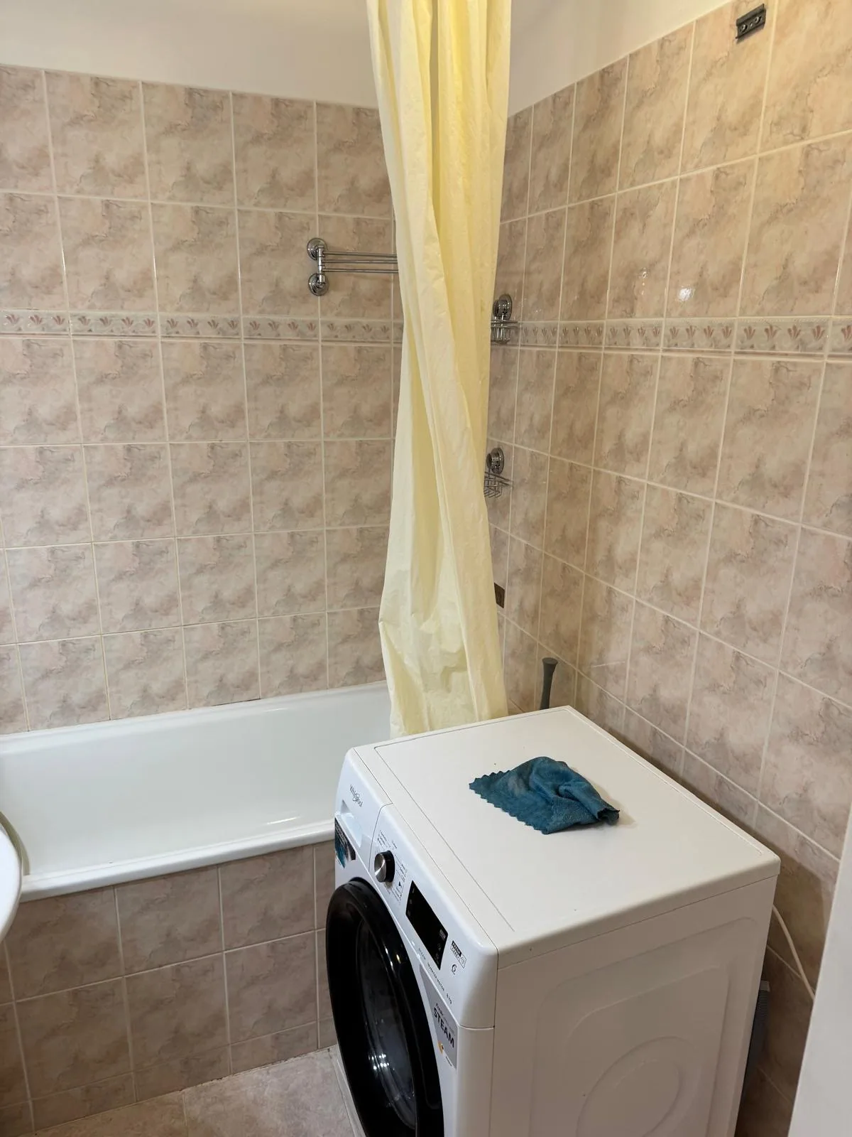 Původní koupelna s vanou, pračkou a béžovým obkladem