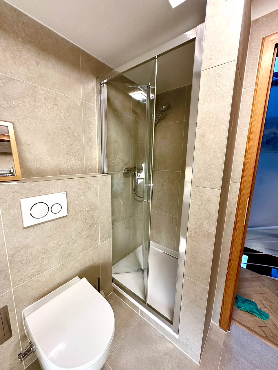 Sprchový kout se závěsným WC u dveří koupelny